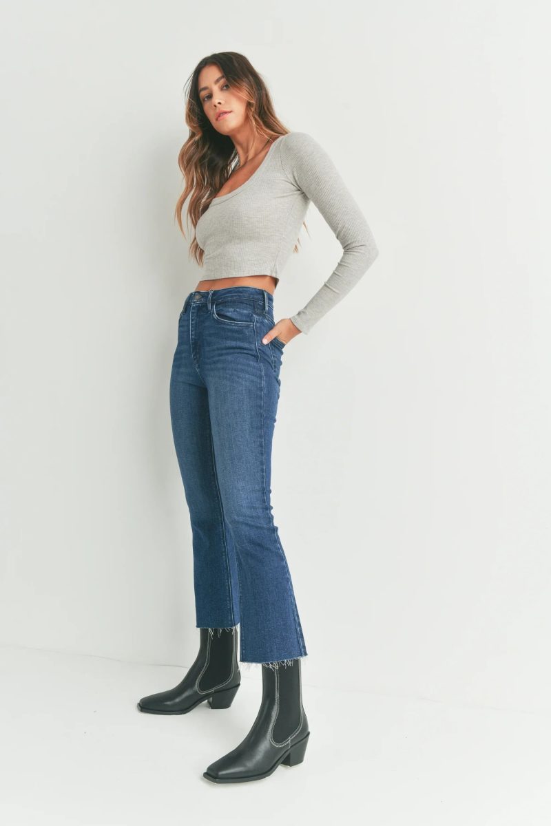 Cropped flare denim jeans styled with a grey long-sleeve top and black leather boots