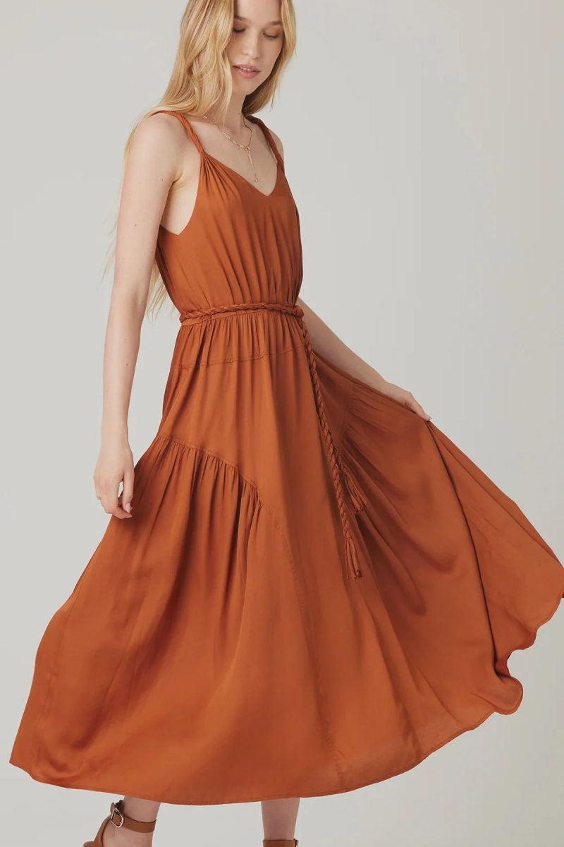 Rust-colored AURA MIDI DRESS featuring a flowy tiered skirt and cinched waist