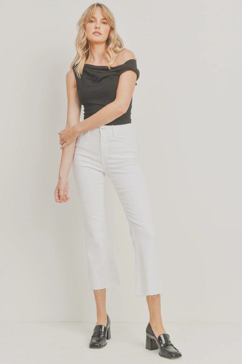 White cropped flare denim styled with a black off-shoulder top and loafers