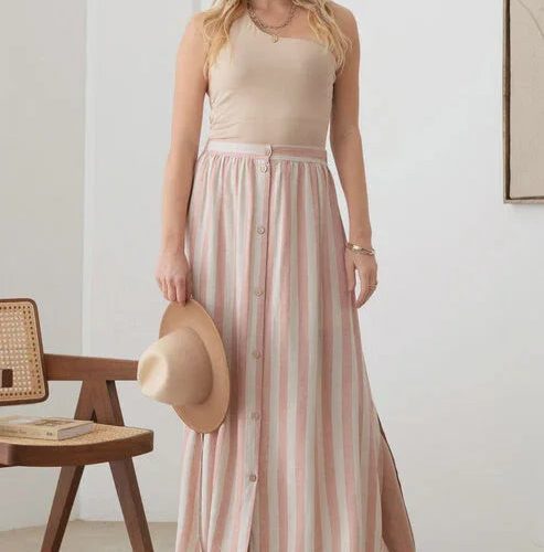 Woman in a pink and white striped maxi skirt with an elastic waist, showcasing boho style