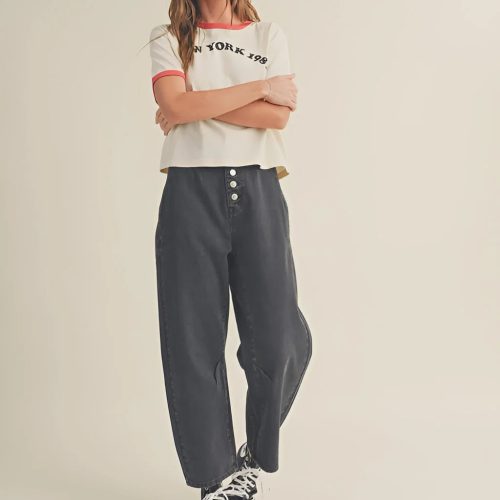 Young woman in washed cotton pants, white t-shirt, and sneakers, arms crossed